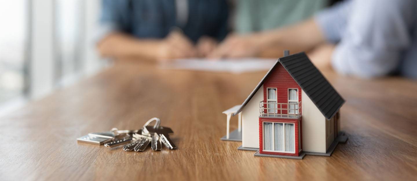 A key and a miniature villa house on table
