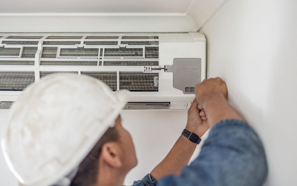 Technician from Affordable AC repair services fixing the air conditioner. 