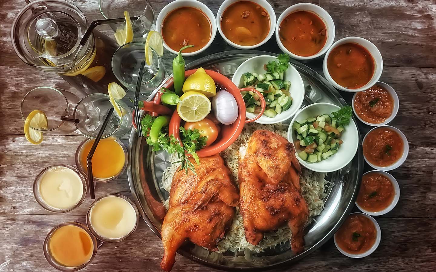 Top view of Chicken Mandy/Kabsa Rice, a kind of Arabian main course complete with side dishes and dessert.