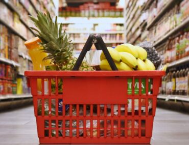Basket filled with fresh produce and essentials inside one of the Budget supermarkets in Dubai during grocery shopping.