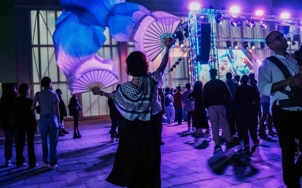 Woman performing with fans at Quoz Arts Fest Dubai