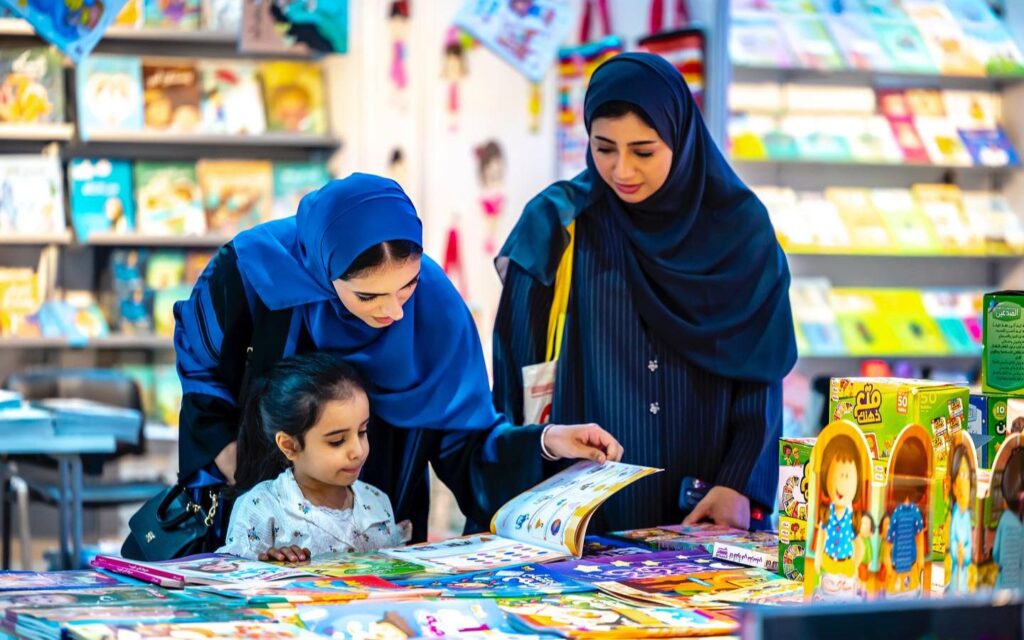 people reading book at Children’s Reading Festival in Sharjah