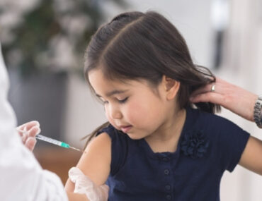 طبيب يحقن مطعوم لطفلة