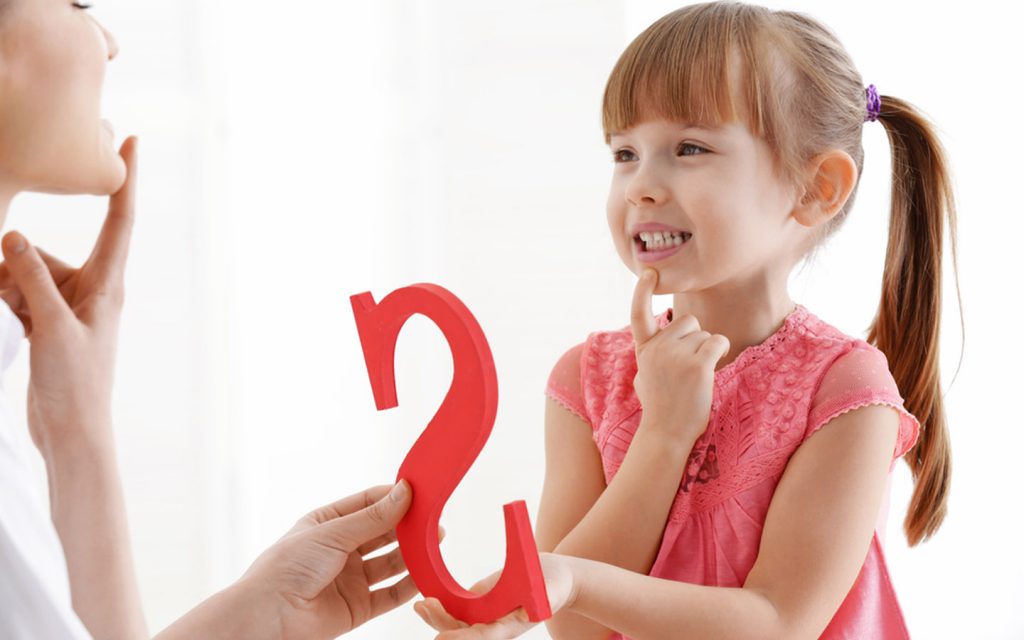 Child learning to pronounce the letter S with speech therapist