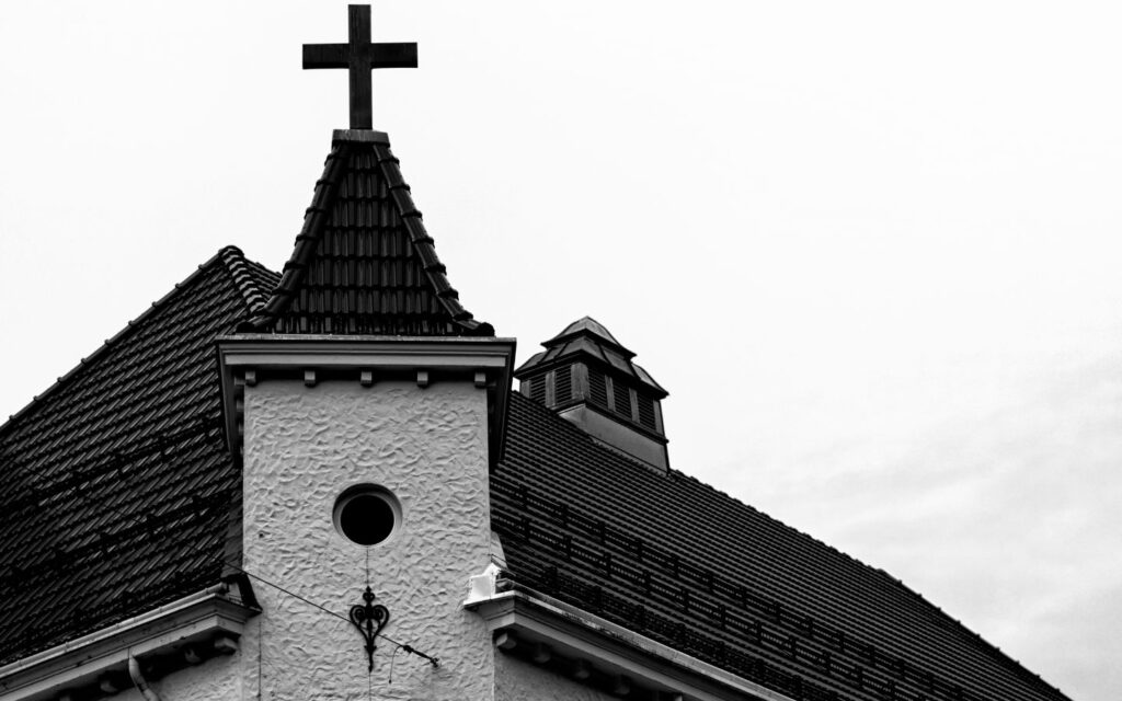 A wide shot of a modern church exterior under a bright blue Abu Dhabi sky.