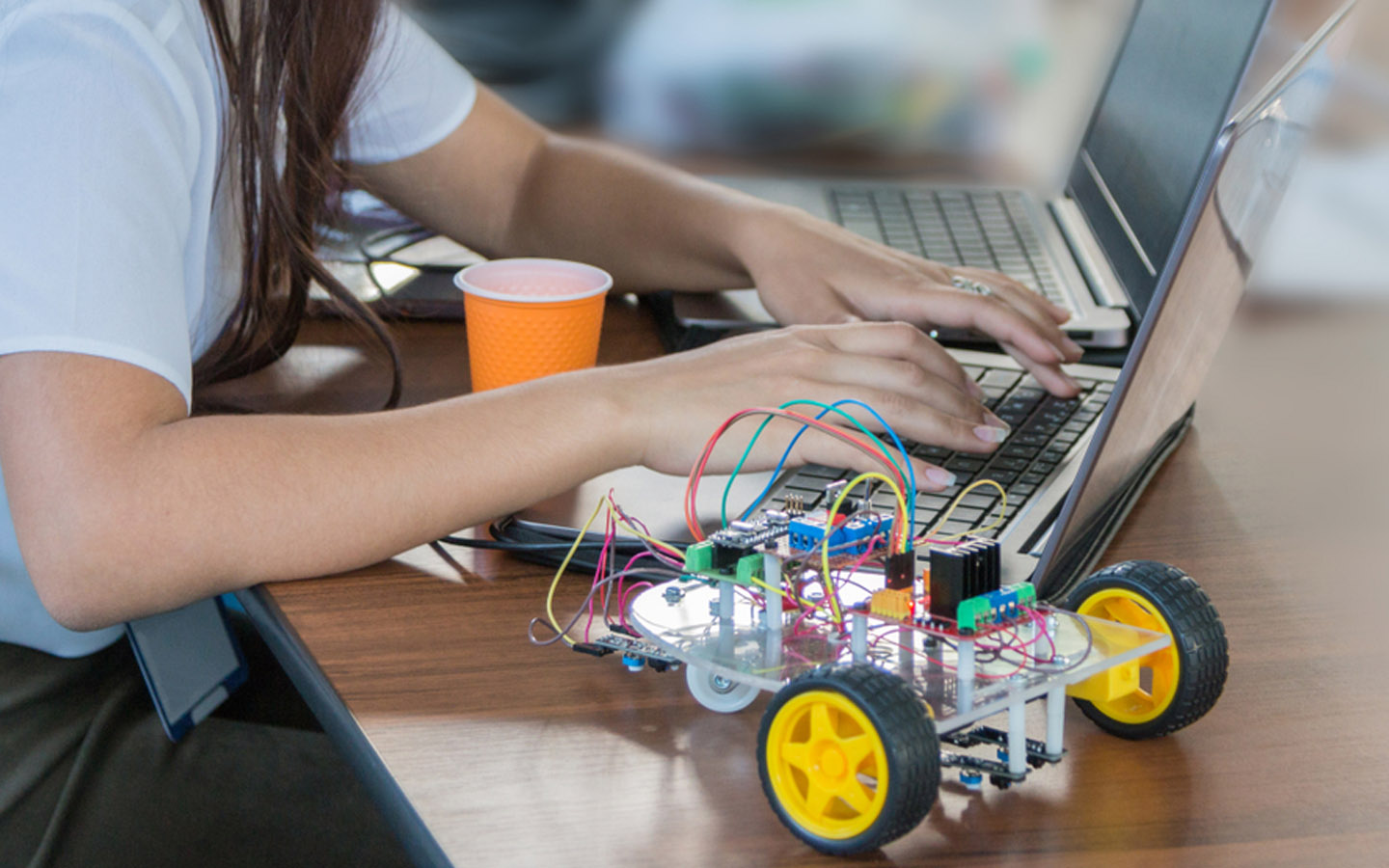 شخص يستخدم الحاسوب لتحريك روبوت