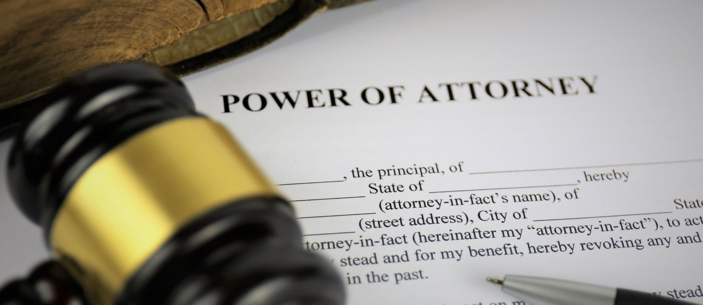 High-angle macro shot of a Power of Attorney legal form next to a wooden judge's gavel and a pen