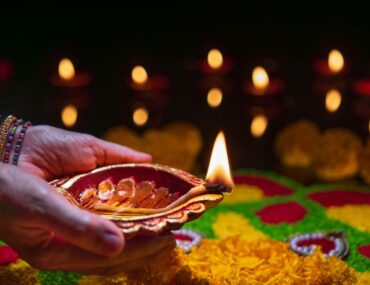 woman lighting diya during diwali celebrations in Dubai