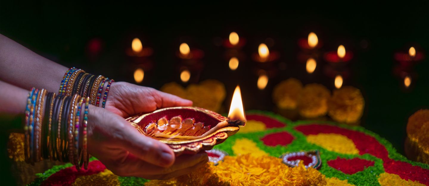 woman lighting diya during diwali celebrations in Dubai