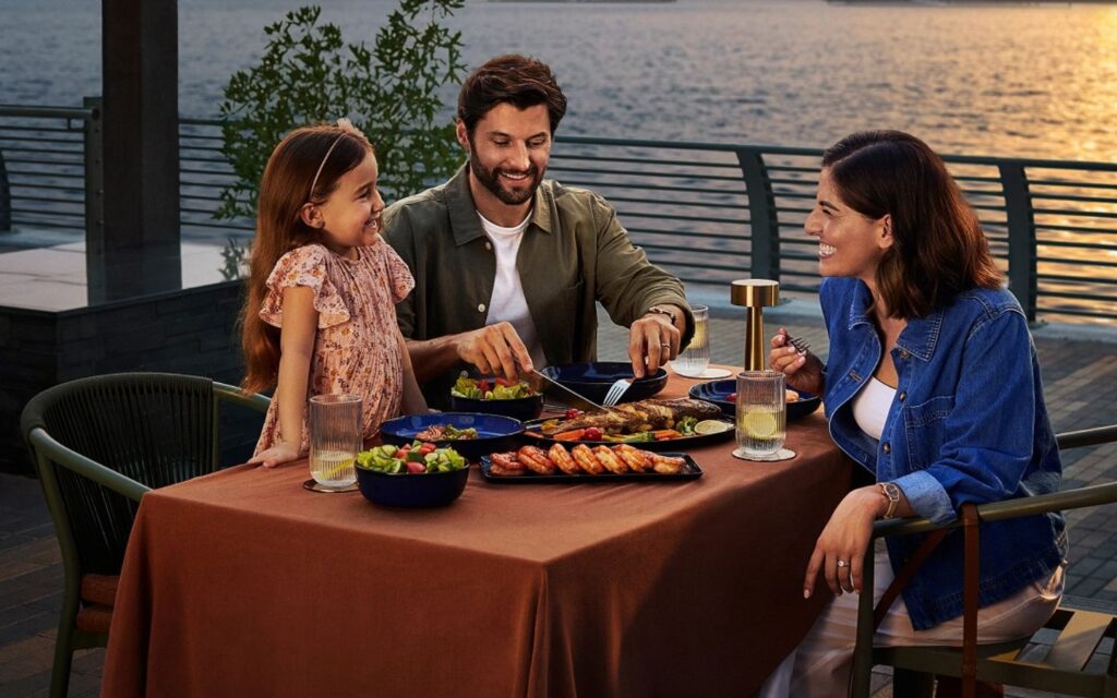 family enjoying food at waterfront market Deira restaurant