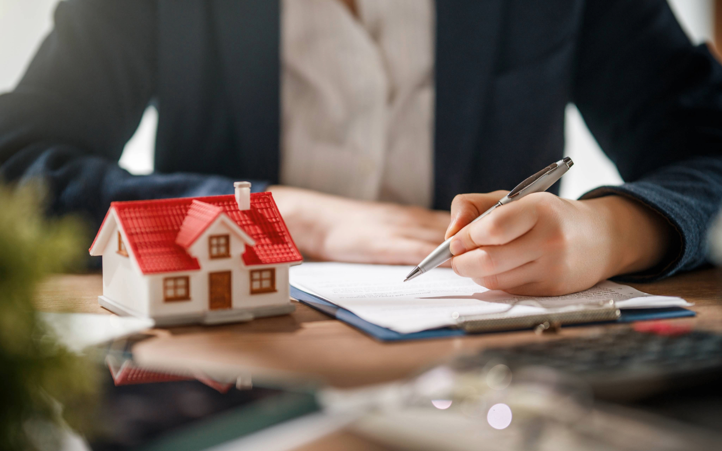 Person holding a pen while reviewing property documents