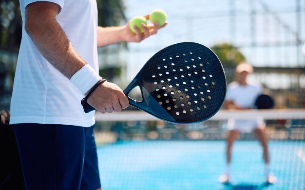 Player holding a padel paddle and a ball