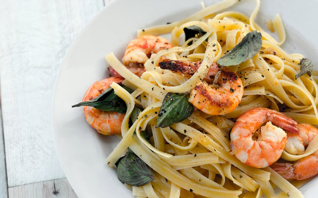 Pasta with grilled prawns served with herbs and black pepper