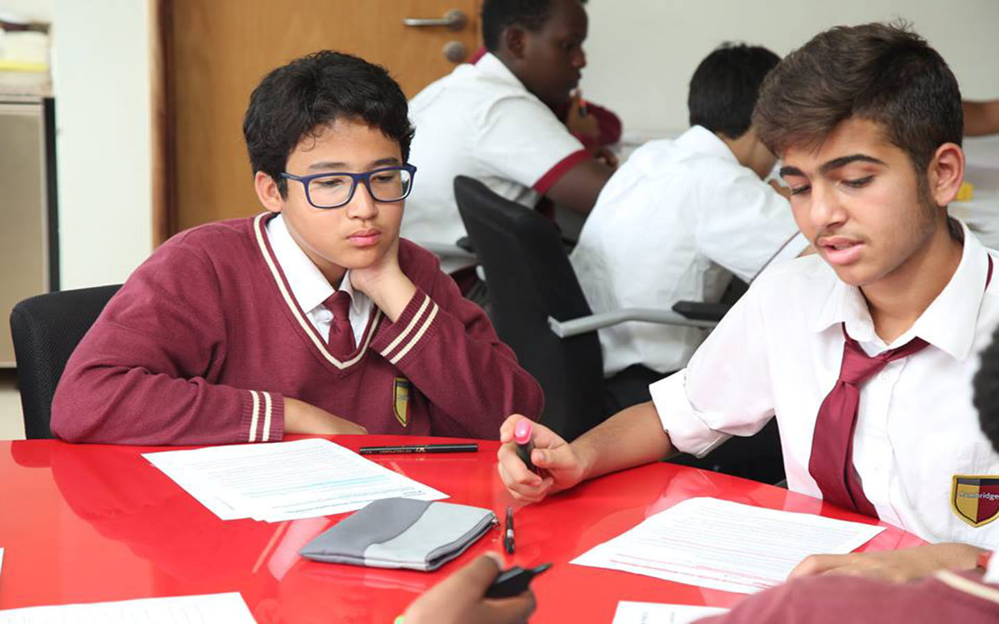 Students discussing ideas with each other at GEMS Cambridge International School)