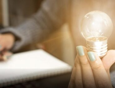 فتاة تمسك مصباح وقلم