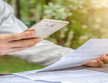 شخص يمسك هاتف وورقة