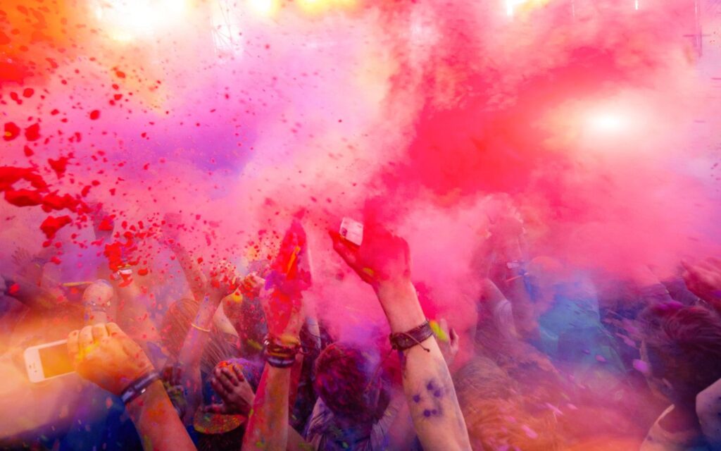 Partygoers enjoying music and color at a festival.