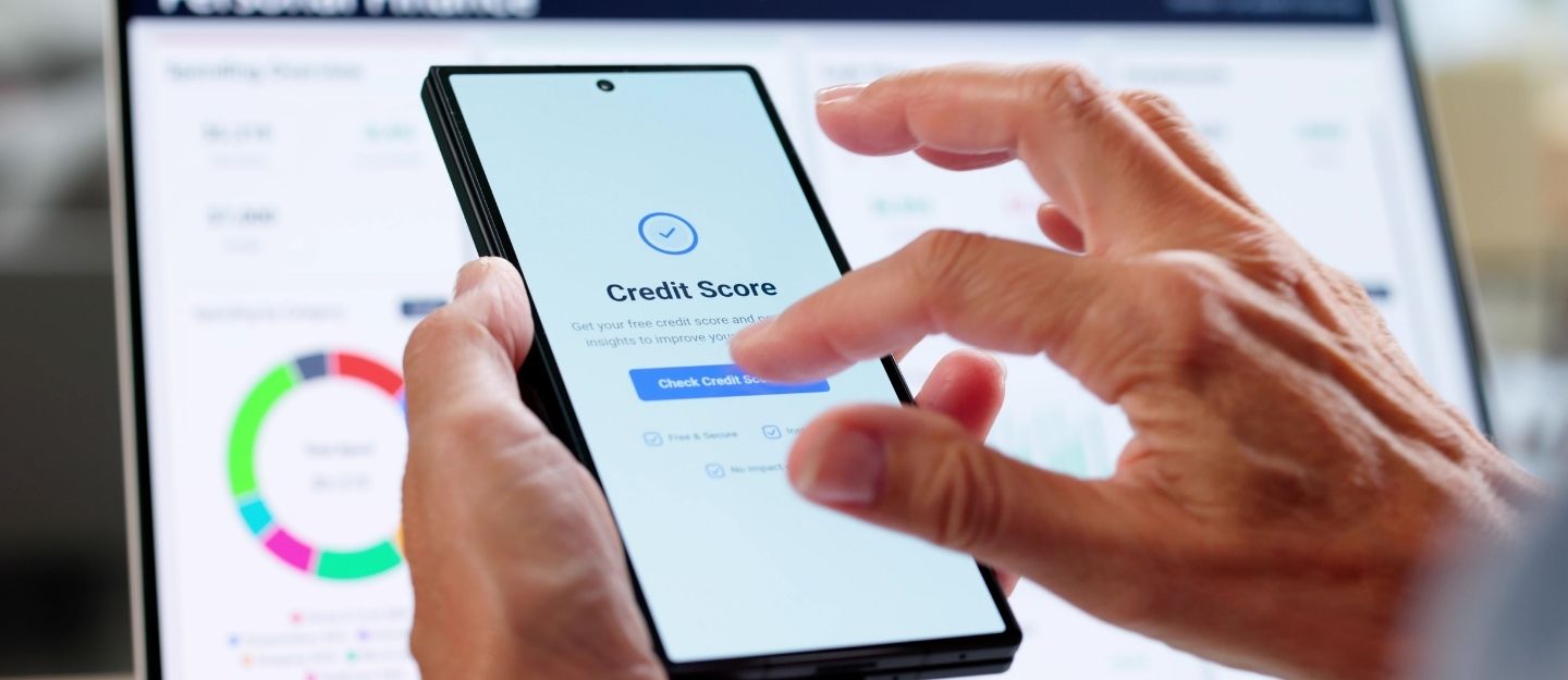 A hand checking a credit score on a smartphone app.