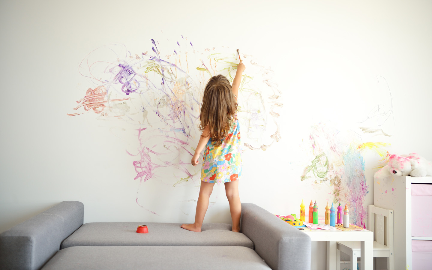 طفلة ترسم على الحائط