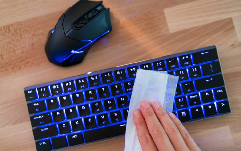 person cleaning the keyboard, which is one of the best coronavirus cleaning advice