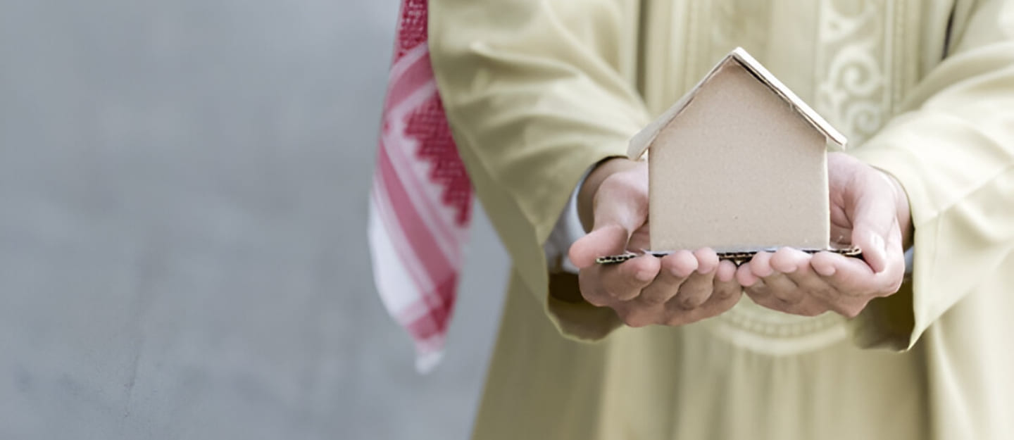 شخص يمسك مجسم بيت