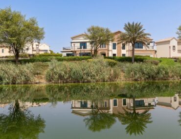 Scenic waterfront view of luxury villas and landscaped gardens in Jumeirah Golf Estates, Dubai