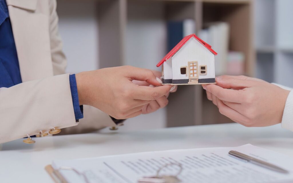 Man handing over miniature house