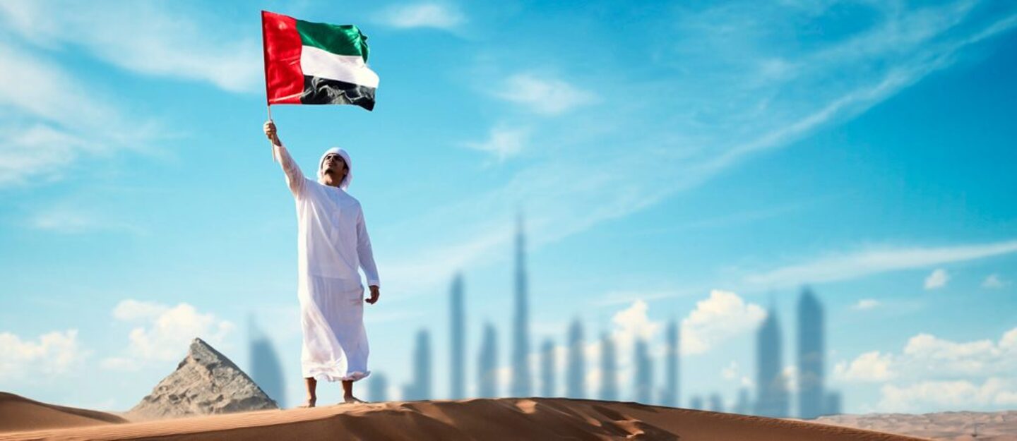 رجل يحمل علم اماراتي