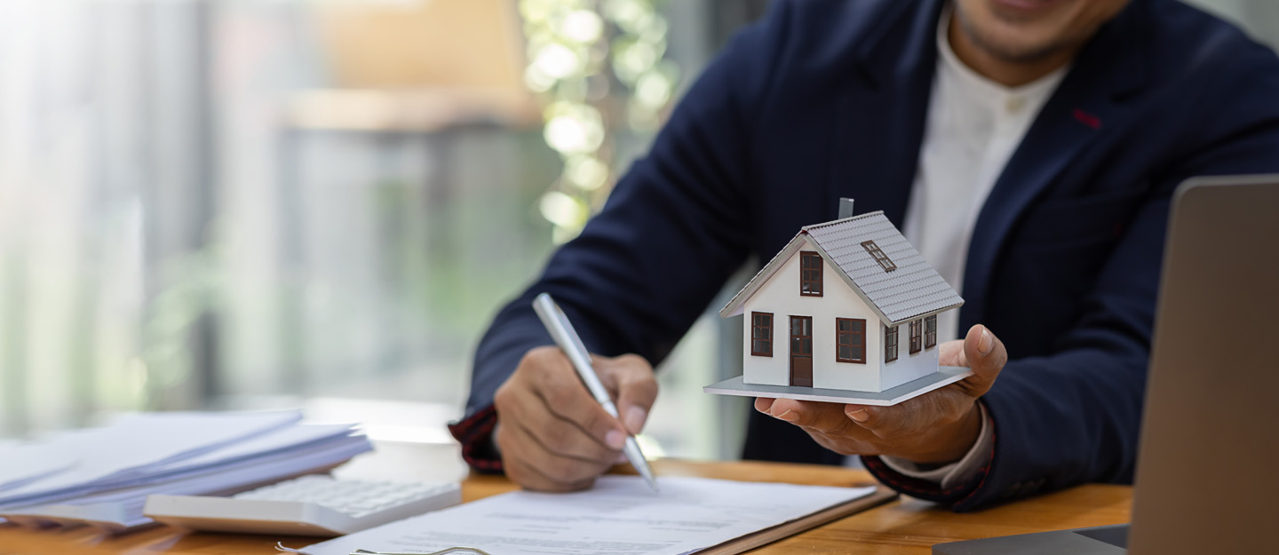 شخص يحمل مجسم بيت ويكتب