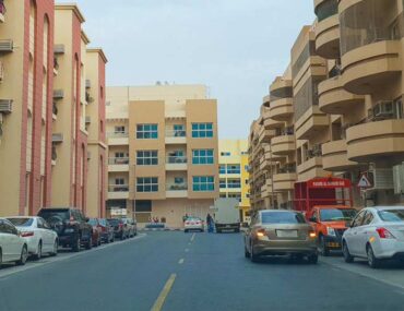 Muhaisnah apartment buildings with cars parked outside