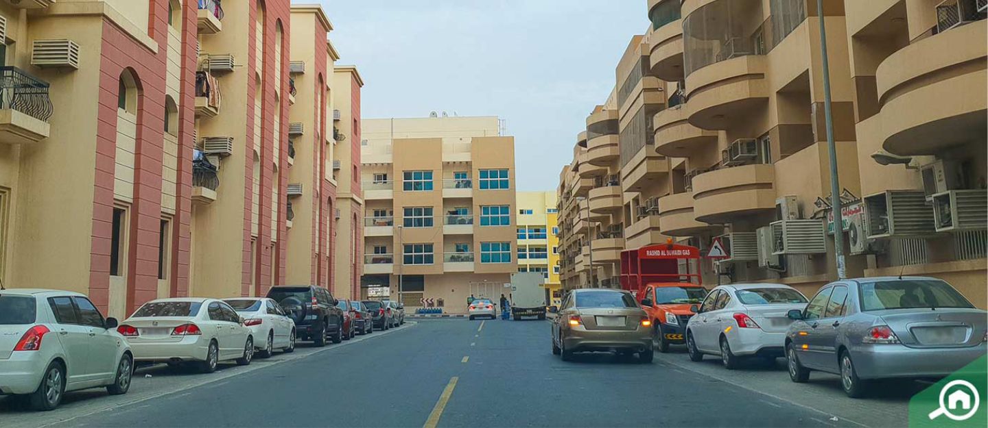 Muhaisnah apartment buildings with cars parked outside