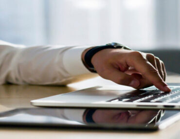 يد تمسك جهاز الكمبيوتر