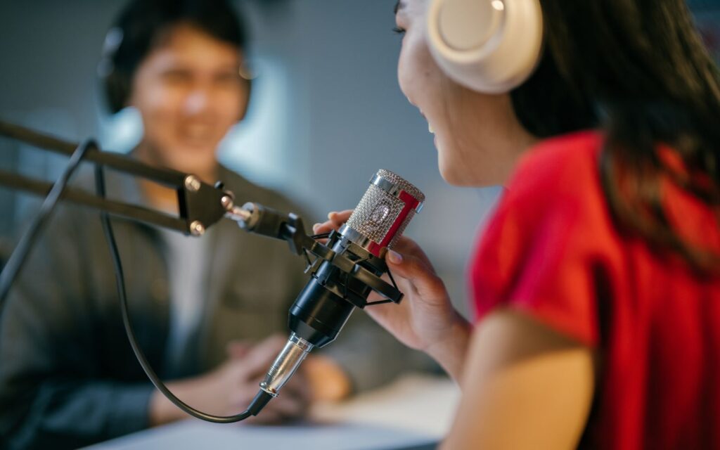 Female radio host speaking on air at a Dubai radio station.