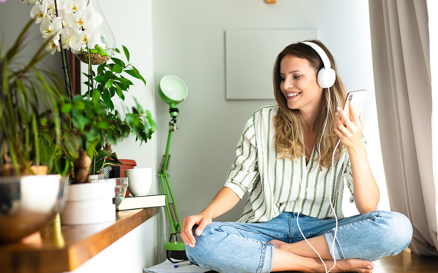 فتاة جالسة بجانب نباتات