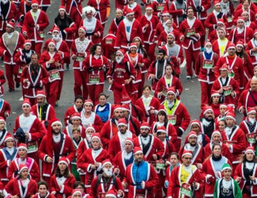 Runners dressed as Santa racing at Dubai Santa Run 2025.