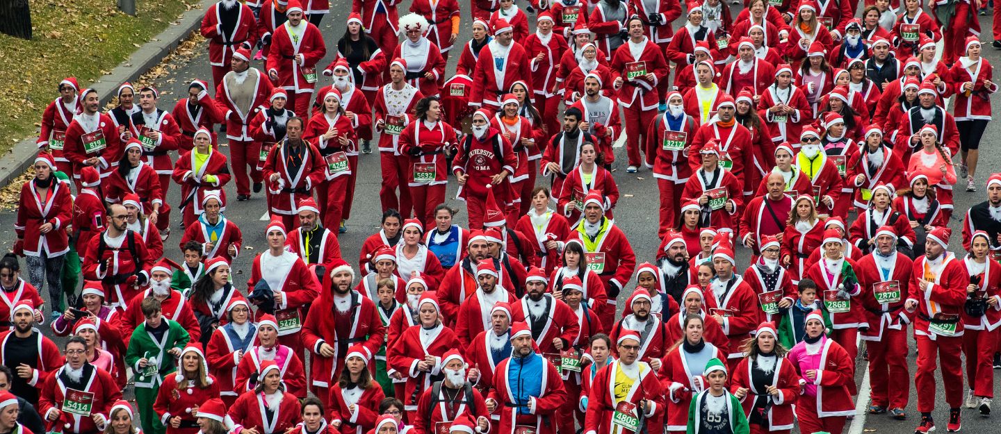 Runners dressed as Santa racing at Dubai Santa Run 2025.