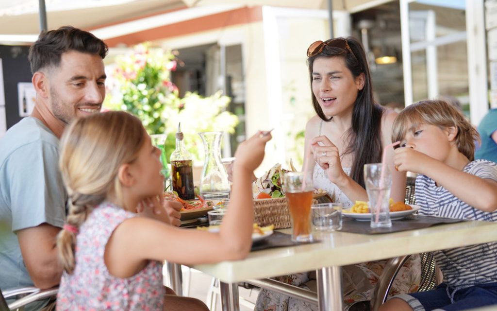 Family dining at a restaurant, using one of the staycation deals Abu Dhabi