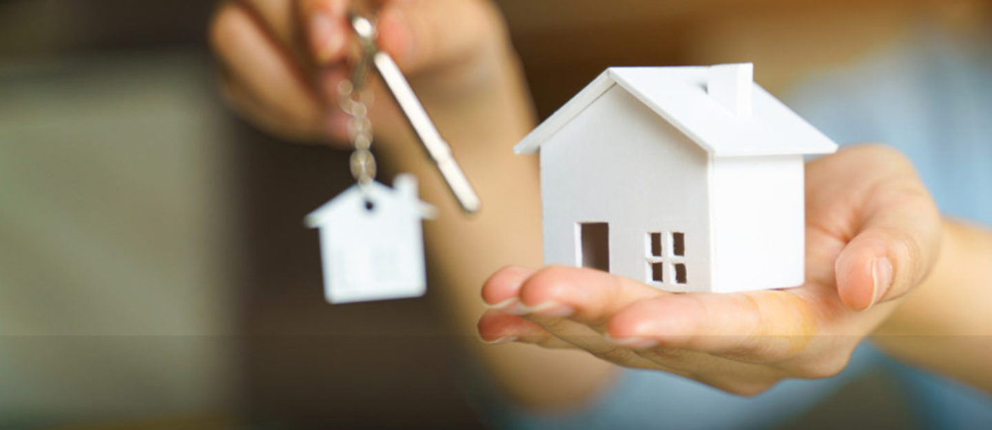 مجسم بيت في يد رجل