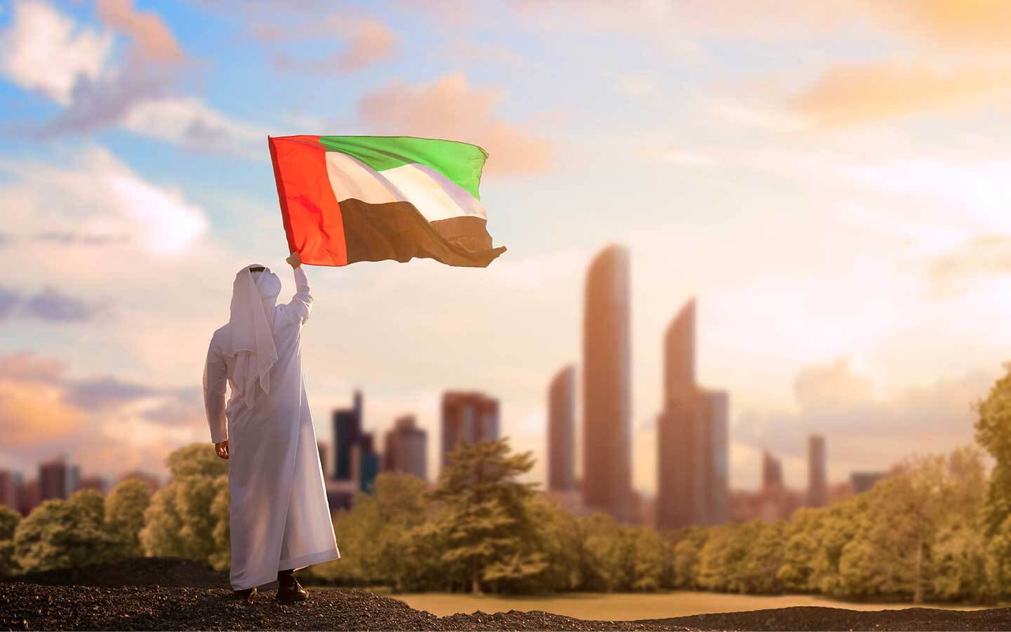 شخص يحمل علم الإمارات