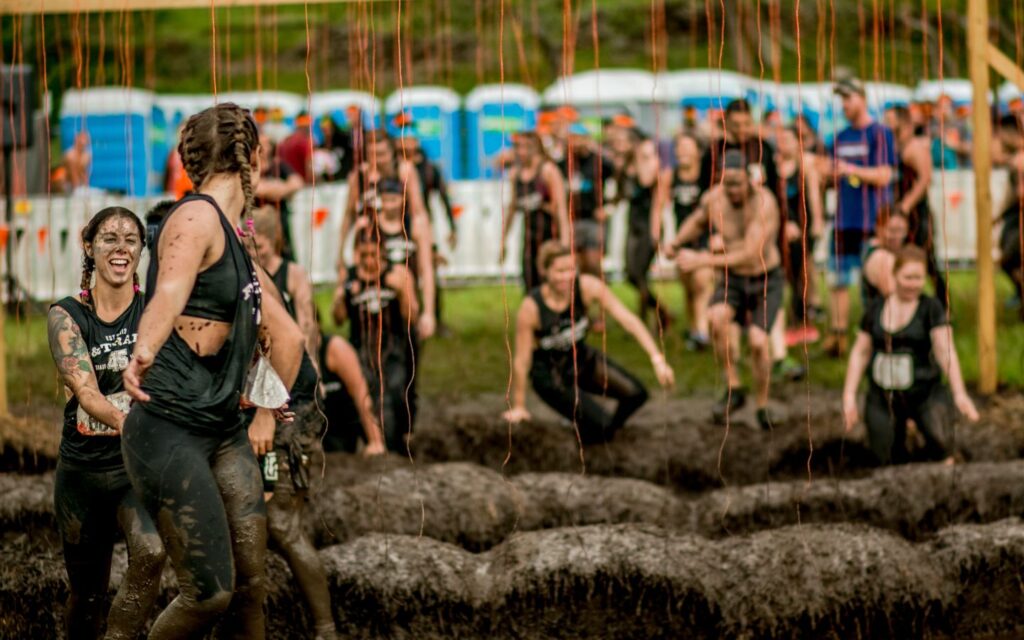 Friends overcoming obstacles at the Dubai endurance event 2025.