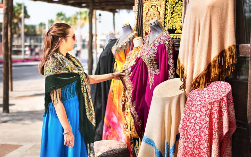 A female tourist browsing scarves in Al Karama souq Dubai