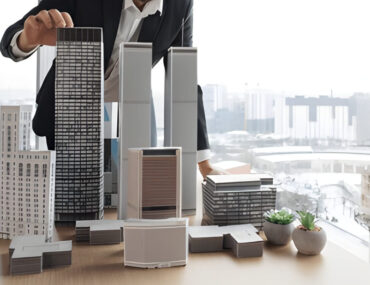 شخص أمامه مجسمات عقارات