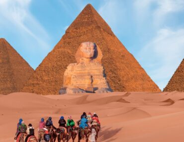 Tourists exploring the pyramids during travel from UAE to Egypt.