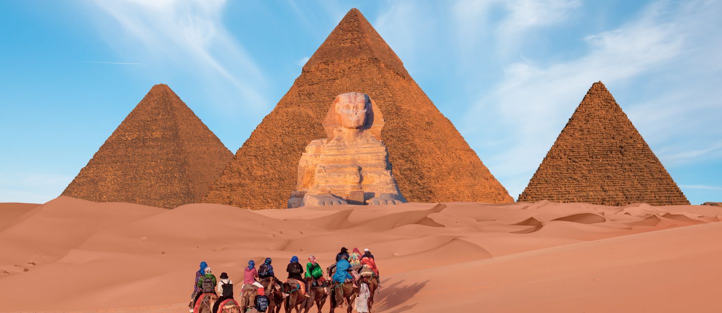 Tourists exploring the pyramids during travel from UAE to Egypt.