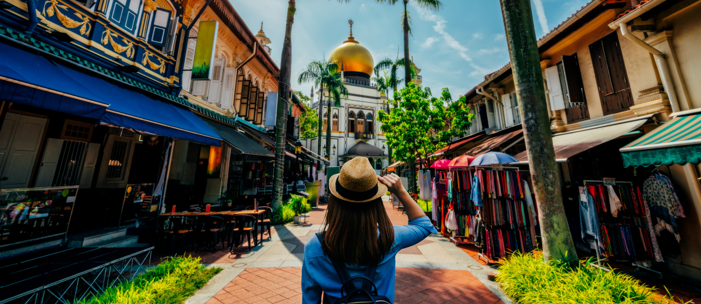 Tourist enjoying a busy shopping street with bright lights and retail stores in Singapore