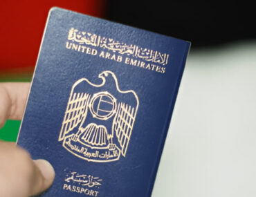 شخص يمسك جوازًا إماراتيًا