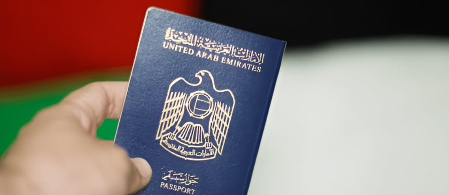 شخص يمسك جوازًا إماراتيًا