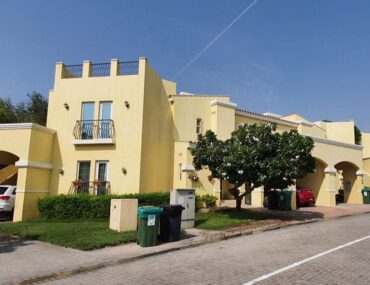 Street view of a 5-bedroom villa in Villanova Dubailand with parked vehicles in the garage