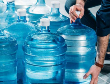 شخص يحمل قوارير المياه