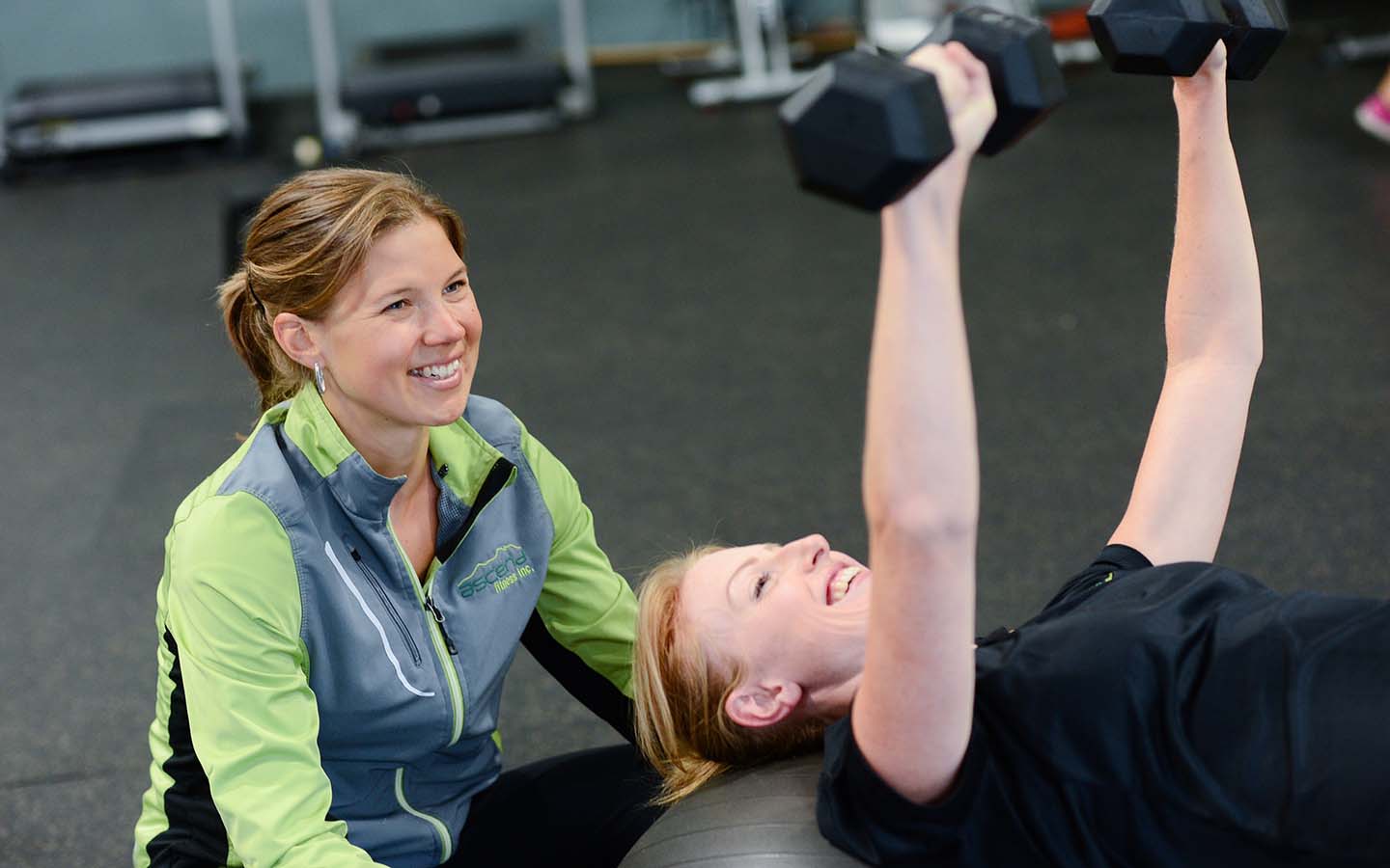 A woman exercises under the guidance of a woman coach